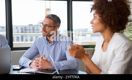 Réunion d'équipe d'affaires collaboration assis autour d'une table dans un bureau moderne ensemble Banque D'Images