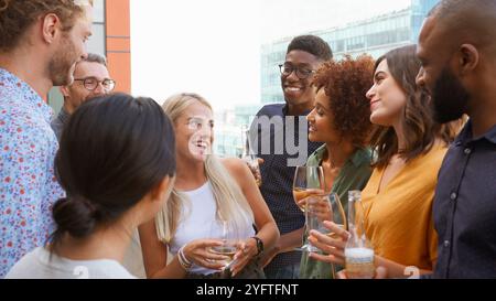 Réunion de l'équipe d'affaires multiculturelle à l'extérieur pour prendre un verre après le travail sur le toit du bureau ou au bar Banque D'Images