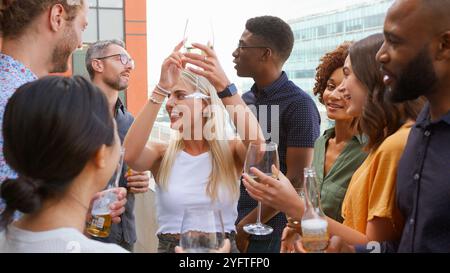 Réunion de l'équipe d'affaires multiculturelle à l'extérieur pour prendre un verre après le travail sur le toit du bureau ou au bar Banque D'Images