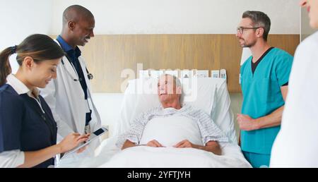 Équipe médicale en tournée visitant un homme senior couché dans un lit d'hôpital privé Banque D'Images