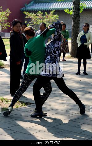 Des dizaines de personnes ayant des cours de danse de salle de bal dans le grand parc de Pékin qui encercle le Temple du ciel. Banque D'Images