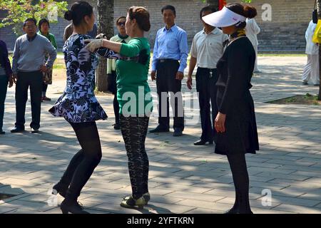 Des dizaines de personnes ayant des cours de danse de salle de bal dans le grand parc de Pékin qui encercle le Temple du ciel. Banque D'Images