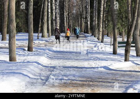 Saint-Pétersbourg, Russie - 17 mars 2023 : devant l'allée il y a des fans de marche nordique en hiver et par beau temps ensoleillé Banque D'Images