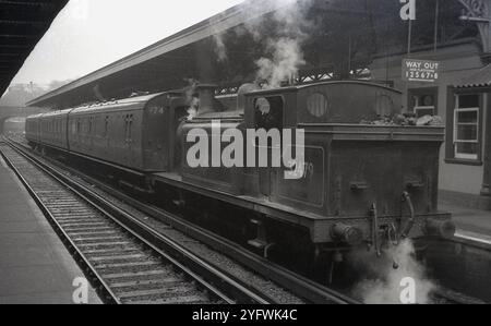 Années 1950, historique, wagons de train et locomotive à vapeur, No 32479 (BR) à la gare, Angleterre, Royaume-Uni. Une locomotive de classe E4 de Billinton, construite à l'origine en 1898 pour des travaux sur le London, Brighton and South Coast Railway (LBSCR), puis sur le Southern Railway (SR). Sur le nouveau British Railway (BR) après 1948, il était principalement employé pour des tâches de manœuvre. Il a été retiré du service en 1963. Banque D'Images