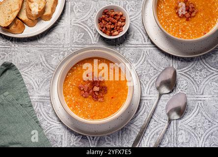 Photographie culinaire de soupe de lentilles rouges avec Chili et bacon, carotte, oignon, ail, pain grillé, bouillon, bouillon, set table Banque D'Images