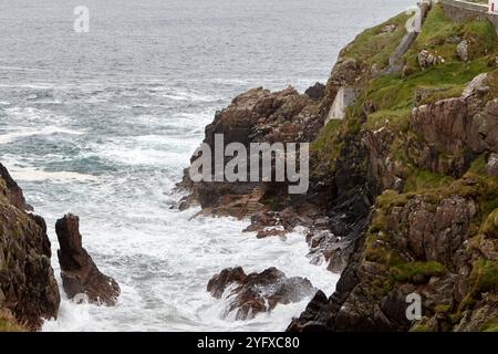 descend du phare au-dessus de la côte rocheuse jusqu'à l'entrée à la mer fanad head, comté de donegal, république d'irlande Banque D'Images