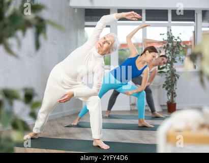 Professeur de yoga adulte montrant d'autres poses de yoga dans le centre de bien-être Banque D'Images