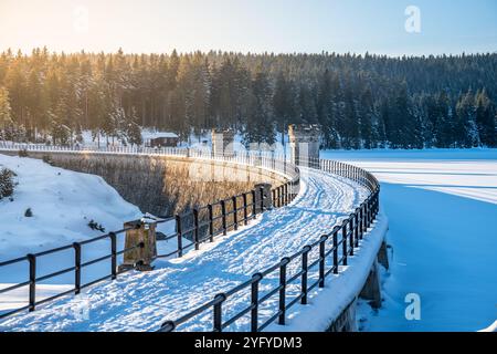 Une journée d'hiver paisible met en valeur le magnifique barrage Cerna Nisa près de Bedrichov, entouré de paysages enneigés et d'arbres, invitant à des activités de plein air et à la détente dans la nature. Banque D'Images