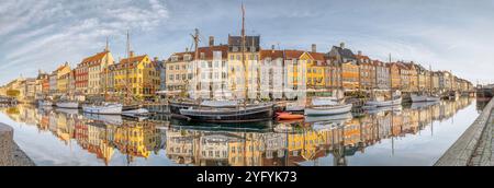 Vue panoramique de Nyhavns Kanal à Copenhague, où les maisons colorées se reflètent dans l'eau calme Banque D'Images