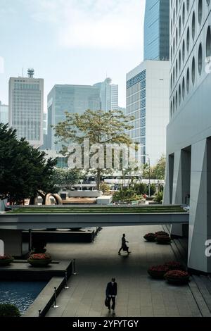 Une personne entre dans Jardine House, qui abrite Jardine Matheson Holdings et ses diverses filiales, illustrant le paysage économique dynamique de Hong Kong Banque D'Images