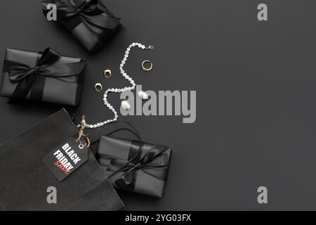 Composition avec sac à provisions, boîtes cadeaux et accessoires féminins élégants sur fond sombre. Solde du vendredi fou Banque D'Images
