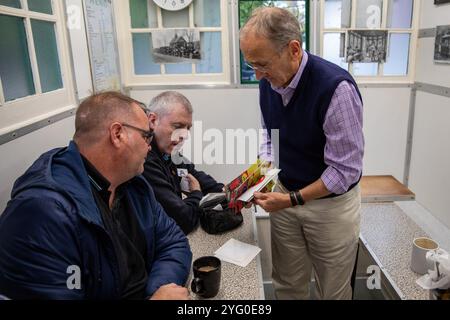 Steve, un bénévole de Poppy Cab distribue des tracts aux chauffeurs de taxi londoniens à l'intérieur d'un Green Hut. Fondée il y a quinze ans par des chauffeurs de taxi londoniens, Poppy Cabs offre des trajets gratuits aux vétérans militaires participant au service annuel du jour du souvenir au cénotaphe de Westminster, à Londres. Inspirés par le Royal British Legionís Poppy Appeal, où les badges rouges du coquelicot sont échangés contre des dons caritatifs, ces chauffeurs de taxi dévoués s’organisent sous l’initiative ìPoppy Cabsî. Chaque année, les chauffeurs offrent des trajets gratuits aux vétérans à partir des principales gares de Londres, assurant ainsi leur arrivée Banque D'Images