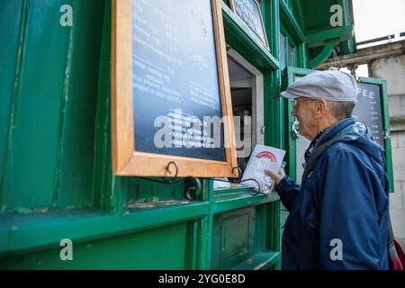 Steve, un bénévole de Poppy Cab remet des tracts au propriétaire d'un refuge Green Hut, Cab Mans Shelter. Fondée il y a quinze ans par des chauffeurs de taxi londoniens, Poppy Cabs offre des trajets gratuits aux vétérans militaires participant au service annuel du jour du souvenir au cénotaphe de Westminster, à Londres. Inspirés par le Royal British Legionís Poppy Appeal, où les badges rouges du coquelicot sont échangés contre des dons caritatifs, ces chauffeurs de taxi dévoués s’organisent sous l’initiative ìPoppy Cabsî. Chaque année, les chauffeurs offrent des trajets gratuits aux vétérans à partir des principales gares de Londres, assurant ainsi leur arrivée Banque D'Images