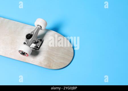 Un skateboard sur fond bleu clair, gros plan. Espace pour le texte Banque D'Images