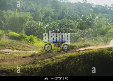 Balikpapan, Indonésie - 7 septembre 2024. Le motocross saute sur un circuit poussiéreux sous le soleil chaud Banque D'Images