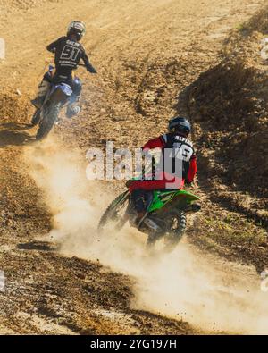 Balikpapan, Indonésie - 7 septembre 2024. Les deux coureurs de motocross pratiquent sur une piste poussiéreuse sous le soleil chaud Banque D'Images