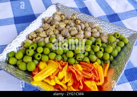 Olives vertes marinées avec champignons et poivron dans une assiette. Banque D'Images