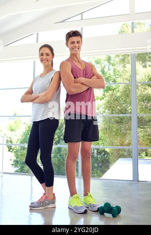 Bras croisés, sport et portrait de couple dans le gymnase avec une attitude positive pour l'entraînement, la santé et le bien-être. Souriez, faites de l'exercice ou des athlètes hommes et femmes Banque D'Images