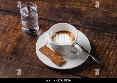 café café macchiato dans une tasse en porcelaine blanche sur une table en bois Banque D'Images