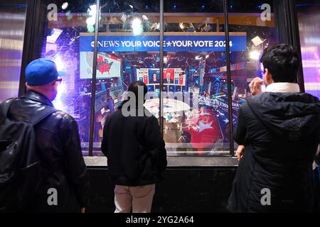 New York, États-Unis. 5 novembre 2024. Les gens regardent une diffusion en direct des résultats du scrutin de sortie pour l'élection présidentielle américaine de 2024 à Times Square à New York, aux États-Unis, le 5 novembre 2024. Projet médiatique le candidat présidentiel républicain Donald Trump a remporté au moins 270 votes du collège électoral. Crédit : Li Rui/Xinhua/Alamy Live News Banque D'Images