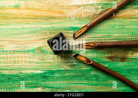 Ensemble de roseaux de calligraphie recouvert d'encre avec encrier sur fond en bois. Encre pour stylo à roseaux pour écrire la calligraphie arabe Banque D'Images