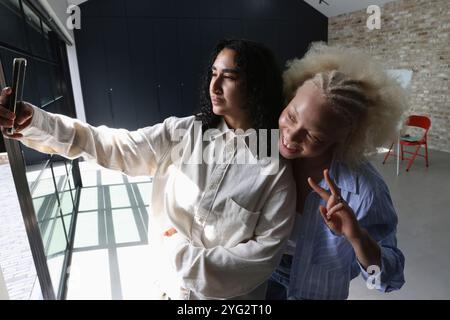Les gens prennent selfie, femme montrant le symbole de la paix Banque D'Images