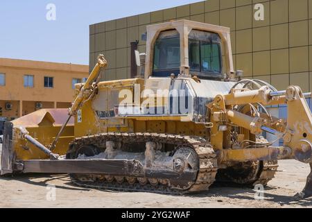 Vieux bulldozer sale extrêmement lourd est arrivé à la station de réparation. Tracteur de terrassement jaune. Machines de chantier industriel. Banque D'Images