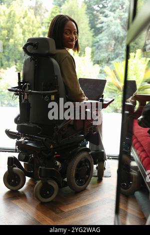 Femme en fauteuil roulant à l'aide d'un ordinateur portable Banque D'Images