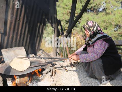 POZANTI, ADANA, TURQUIE-30 OCTOBRE 2016 : vieille femme turque non identifiée fabriquant une tortilla maison pour la nourriture turque Sikma Banque D'Images