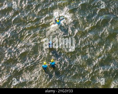 Les gens nagent sur la mer en kitesurf ou en kitesurf. Sport d'été apprendre à faire du kitesurf. Cours de kitesurf sur la baie. Kite surf sur la baie. Banque D'Images