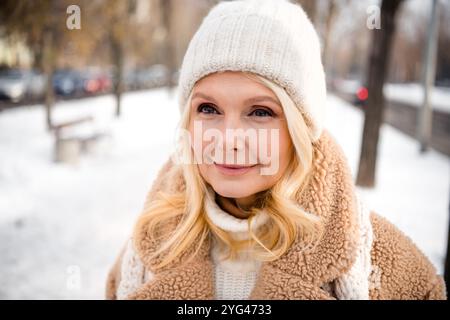 Photo de charmante femme habillée manteau chaud et chapeau profitant de vacances nouvel an temps à l'extérieur Banque D'Images