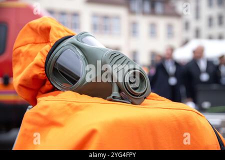 06 novembre 2024, Bavière, Würzburg : une combinaison d'appareil respiratoire se trouve devant un véhicule des pompiers. Lors d'une exposition dans le cadre de l'exercice antiterroriste MainTex 2024, la police, les forces armées allemandes, les pompiers, BRK et d'autres services d'urgence démontrent leurs compétences et leur équipement. Photo : Pia Bayer/dpa Banque D'Images