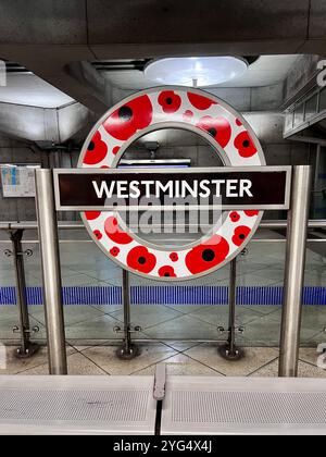 Métro de Londres, panneau de la station de métro Westminster décoré de coquelicots pour célébrer le jour du souvenir. Banque D'Images