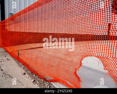 Barrière de construction en plastique orange déchiré Banque D'Images