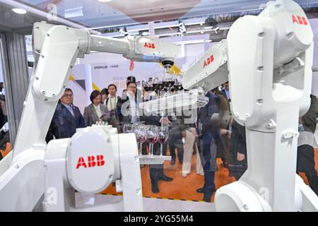 Shanghai. 6 novembre 2024. Les visiteurs regardent la démonstration de défi de haute performance d'une armoire de commande sur le stand d'ABB dans la zone d'exposition de l'industrie intelligente et des technologies de l'information lors de la septième exposition internationale d'importation de Chine (CIIE) à Shanghai, dans l'est de la Chine, le 6 novembre 2024. Le CIIE en cours présente une technologie de pointe et des équipements haut de gamme, fournissant une plate-forme de communication pour le secteur des nouveaux matériaux. Crédit : Zhang Cheng/Xinhua/Alamy Live News Banque D'Images