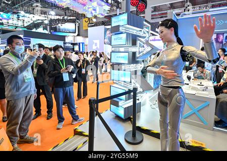 Shanghai. 6 novembre 2024. Les visiteurs regardent un robot humanoïde danser dans la zone d'exposition de l'industrie intelligente et des technologies de l'information lors de la septième exposition internationale d'importation de Chine (CIIE) à Shanghai, dans l'est de la Chine, le 6 novembre 2024. Le CIIE en cours présente une technologie de pointe et des équipements haut de gamme, fournissant une plate-forme de communication pour le secteur des nouveaux matériaux. Crédit : Zhang Cheng/Xinhua/Alamy Live News Banque D'Images