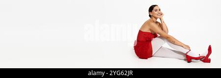 Une femme confiante en rouge pose élégamment, mettant en valeur sa tenue élégante et son calme. Banque D'Images