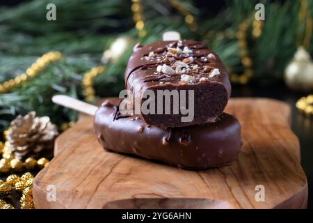 Gâteaux au chocolat popsicle avec des noix sur le bâton sur la planche de bois Banque D'Images