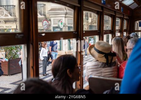 Lisboa, Portugal - 04 juin 2024 - passagers regardant par la fenêtre d'un tramway historique passant par la célèbre rue Augusta à Lisboa, Portugal Banque D'Images