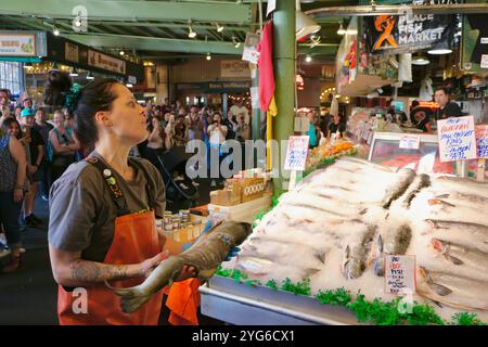 Célèbre pour le poisson jetant les achats des clients avant d'emballer Pike place Fish Market Seattle Washington State USA Banque D'Images