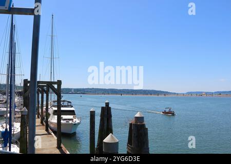 Un petit bateau passant devant Everett Marina dans Puget Sound avec Jetty Island Seattle Washington State USA Banque D'Images