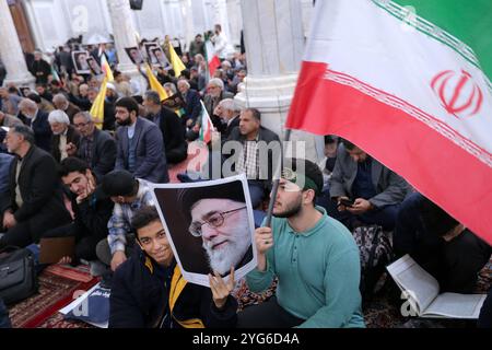 Téhéran, Iran. 6 novembre 2024. Un iranien tient une affiche du Guide suprême iranien, l'ayatollah Ali Khamenei, et agite le drapeau iranien lors d'une cérémonie commémorant les responsables du Hezbollah à Téhéran. Le 6 novembre, les médias américains ont annoncé la victoire de Donald Trump sur Kamala Harris à l'élection présidentielle, marquant un retour politique majeur. Trump, le candidat républicain, a dépassé les 270 votes du collège électoral, devenant le 47e président des États-Unis et retournant à la Maison Blanche après avoir battu le candidat démocrate et actuel vice-président, Kamala Harris. (Crédit image : © I Banque D'Images