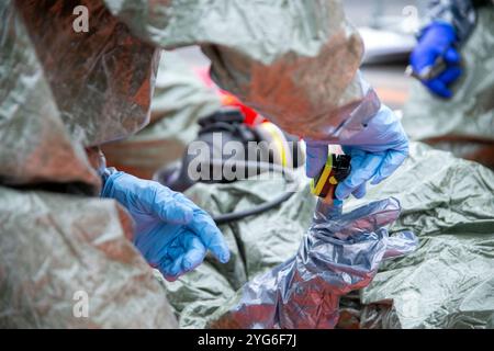 06 novembre 2024, Bavière, Würzburg : lors d'un spectacle dans le cadre de l'exercice antiterroriste MainTex 2024, un oxymètre est utilisé pour mesurer la teneur en oxygène dans le sang d'un travailleur d'urgence qui est entré en contact avec une substance toxique malgré le port de vêtements de protection. Photo : Pia Bayer/dpa Banque D'Images