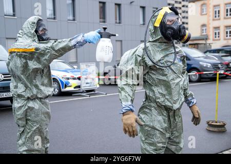 06 novembre 2024, Bavière, Würzburg : lors d'un spectacle dans le cadre de l'exercice antiterroriste 'MainTex 2024', un policier portant un masque respiratoire est décontaminé par un autre policier vêtu de vêtements spéciaux. Photo : Pia Bayer/dpa Banque D'Images