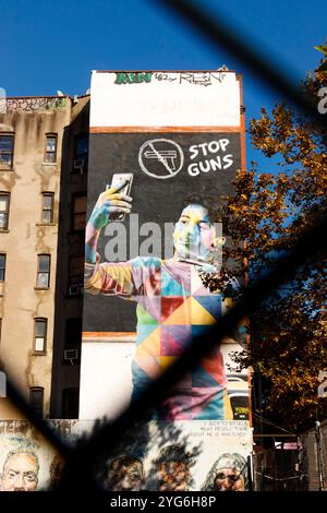 Murale de rue Stop Guns de l'artiste brésilien Edouard Kobra Eldridge Street New york représentant un message contre la violence armée sur la construction d'une clôture à maillons de chaîne Banque D'Images