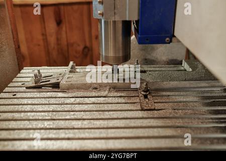 Percez des trous de perceuse industrielle de machine métallurgique en détail de l'équipement de traitement sur le plan de travail avec de la poussière métallique Banque D'Images