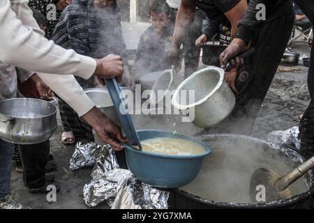 Gaza City, Palestine. 06 novembre 2024. Des Palestiniens déplacés de Beit Lahia et Jabalia reçoivent de la nourriture distribuée par des organisations caritatives dans le quartier de Nasser, dans la ville de Gaza, à Gaza. La crise alimentaire à Gaza se poursuit en raison du blocus israélien qui a été durci ces derniers jours. Crédit : SOPA images Limited/Alamy Live News Banque D'Images