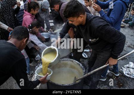 Gaza City, Palestine. 06 novembre 2024. Des Palestiniens déplacés de Beit Lahia et Jabalia reçoivent de la nourriture distribuée par des organisations caritatives dans le quartier de Nasser, dans la ville de Gaza, à Gaza. La crise alimentaire à Gaza se poursuit en raison du blocus israélien qui a été durci ces derniers jours. Crédit : SOPA images Limited/Alamy Live News Banque D'Images