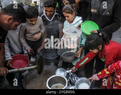 Gaza City, Palestine. 06 novembre 2024. Des Palestiniens déplacés de Beit Lahia et Jabalia reçoivent de la nourriture distribuée par des organisations caritatives dans le quartier de Nasser, dans la ville de Gaza, à Gaza. La crise alimentaire à Gaza se poursuit en raison du blocus israélien qui a été durci ces derniers jours. (Photo de Mahmoud Issa/SOPA images/SIPA USA) crédit : SIPA USA/Alamy Live News Banque D'Images