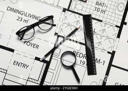Règle, lunettes, loupe et crayon sur différents dessins architecturaux, vue de dessus Banque D'Images